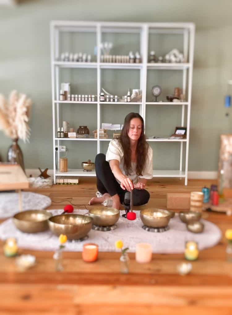 Kalifornië klankschalen meditatie ruimte met vrouw die volle klankschalen bespeelt.