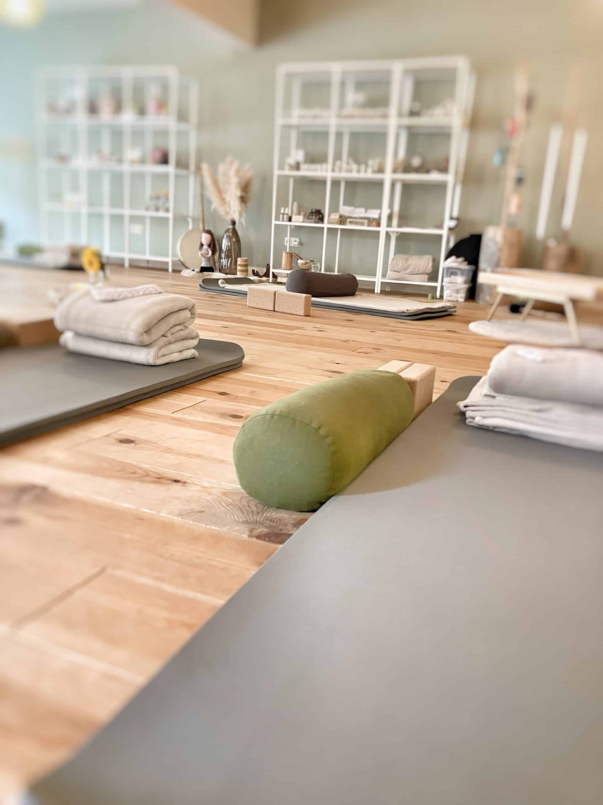 Minimalistische wellnessruimte met meditatiekussens en zachte handdoeken voor ontspanning.