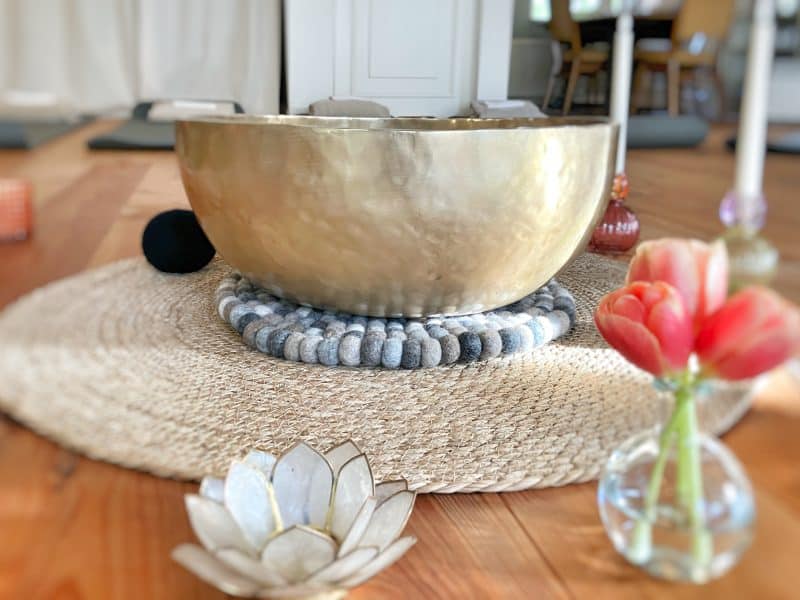 Klanghouder van Tibetaanse meditatie, decoratief eettabel, met bloem en kaarsen voor rust en sereniteit.