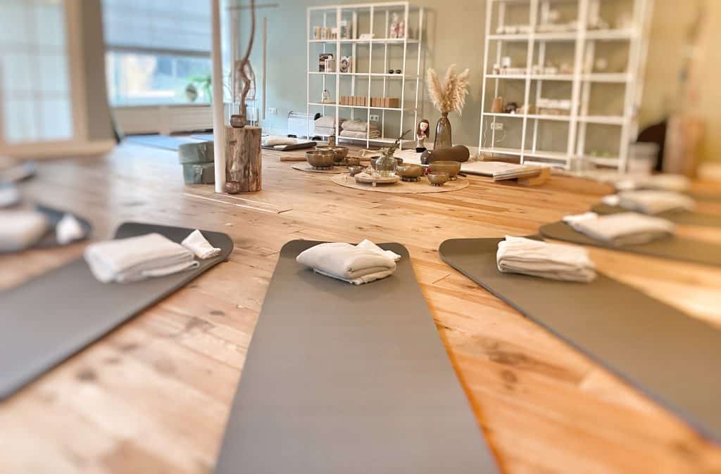 Rustieke yoga vloer met meditatiekussens en accessoires bij Bezenza wellness.