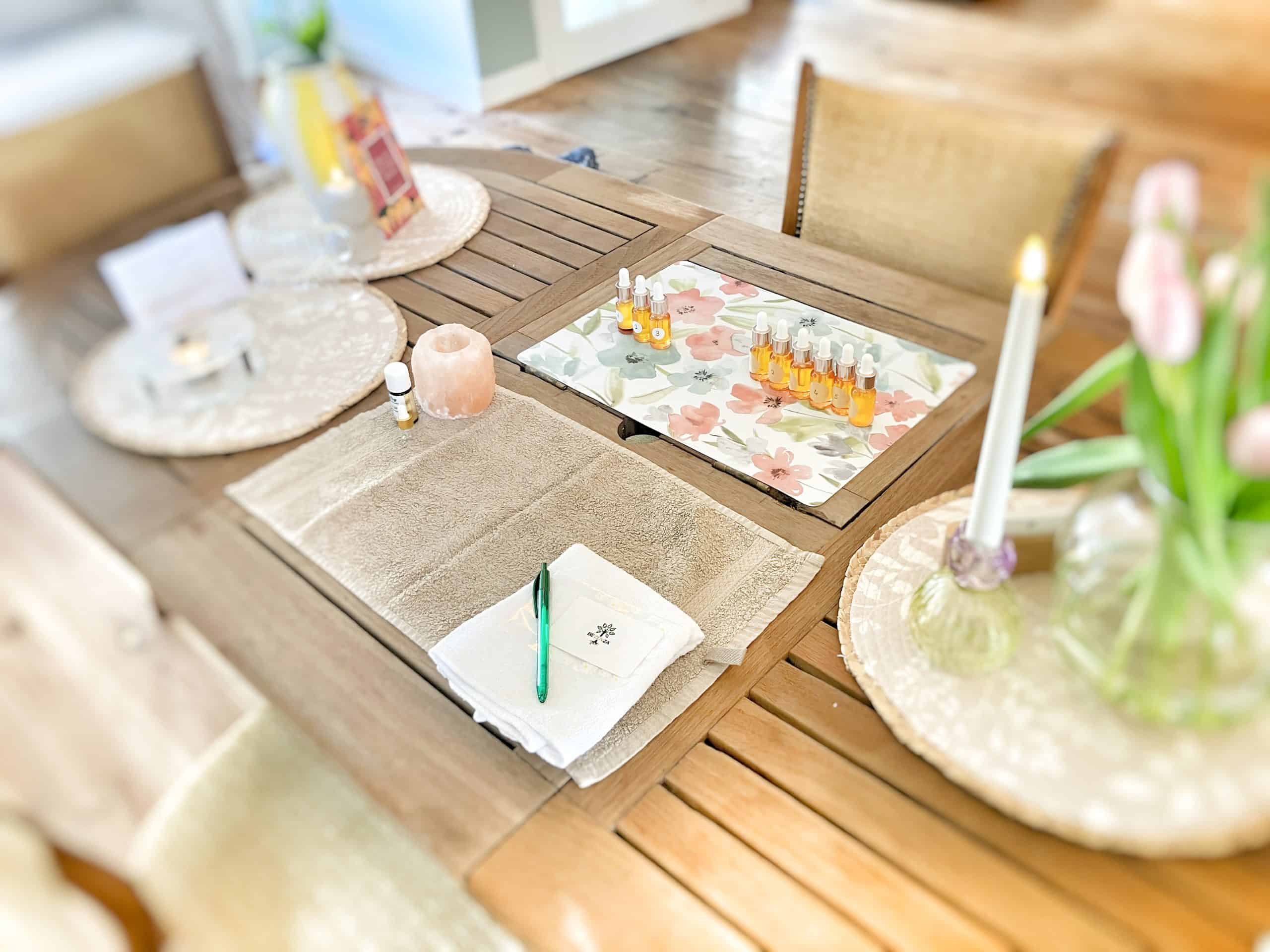 Aromatherapie set op eettafel met etherische oliën en accessoires.