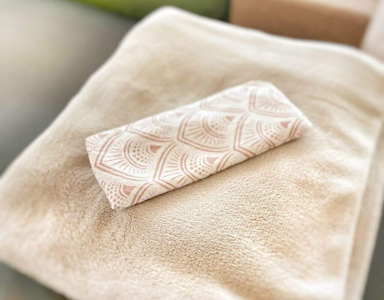 Zachte beige handdoek met geurige badhanddoek op bed, rust en ontspanning vullen de spa-omgeving.