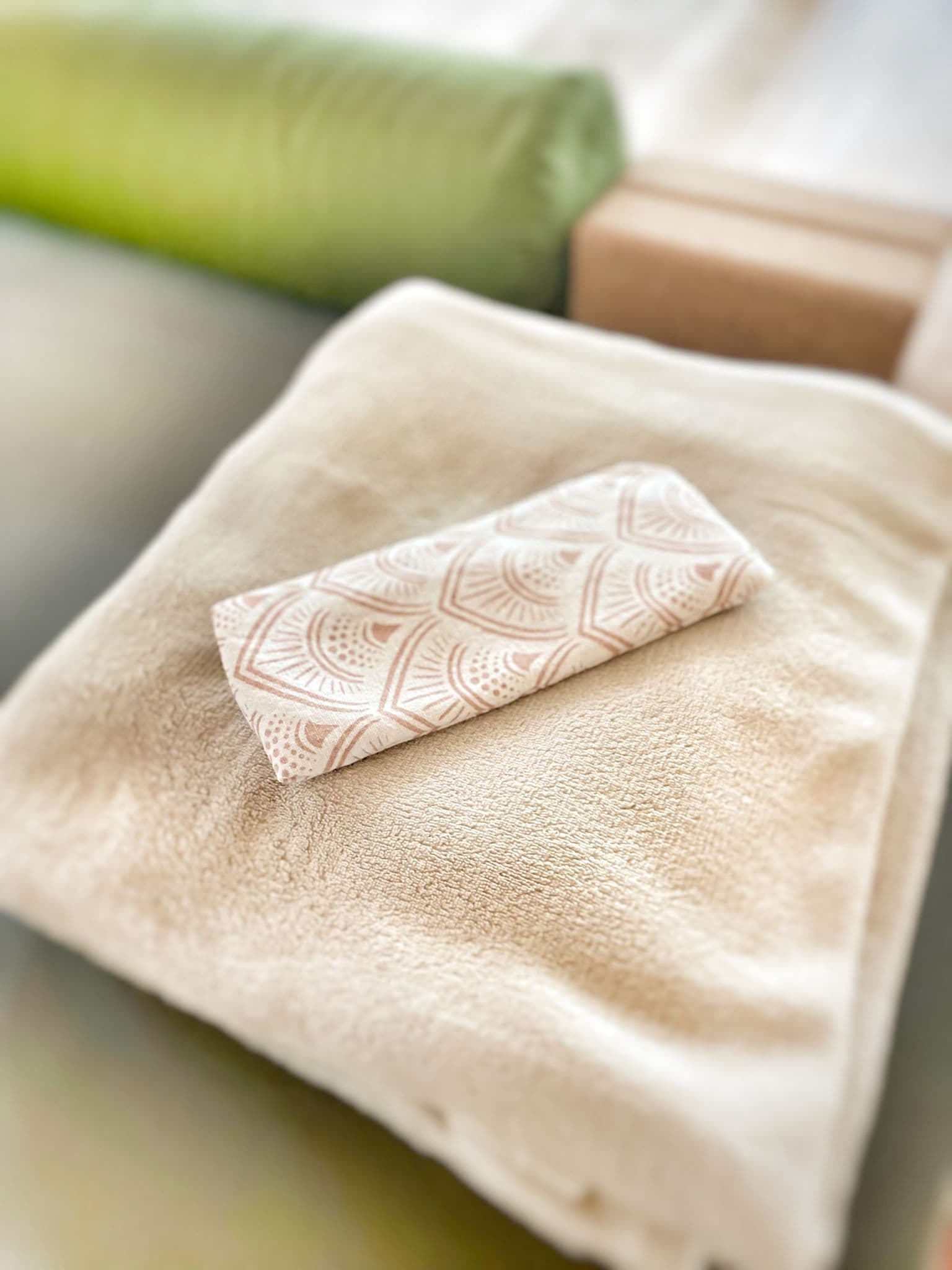 Zachte beige handdoek met geurige badhanddoek op bed, rust en ontspanning vullen de spa-omgeving.